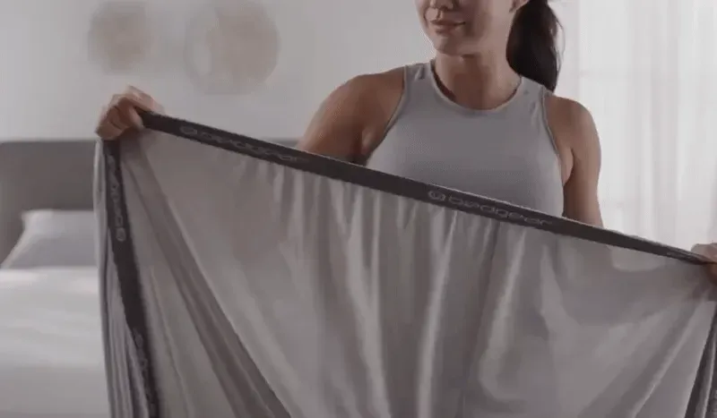 video clip of fitted sheet being stretched over mattress corner to show secure fit.