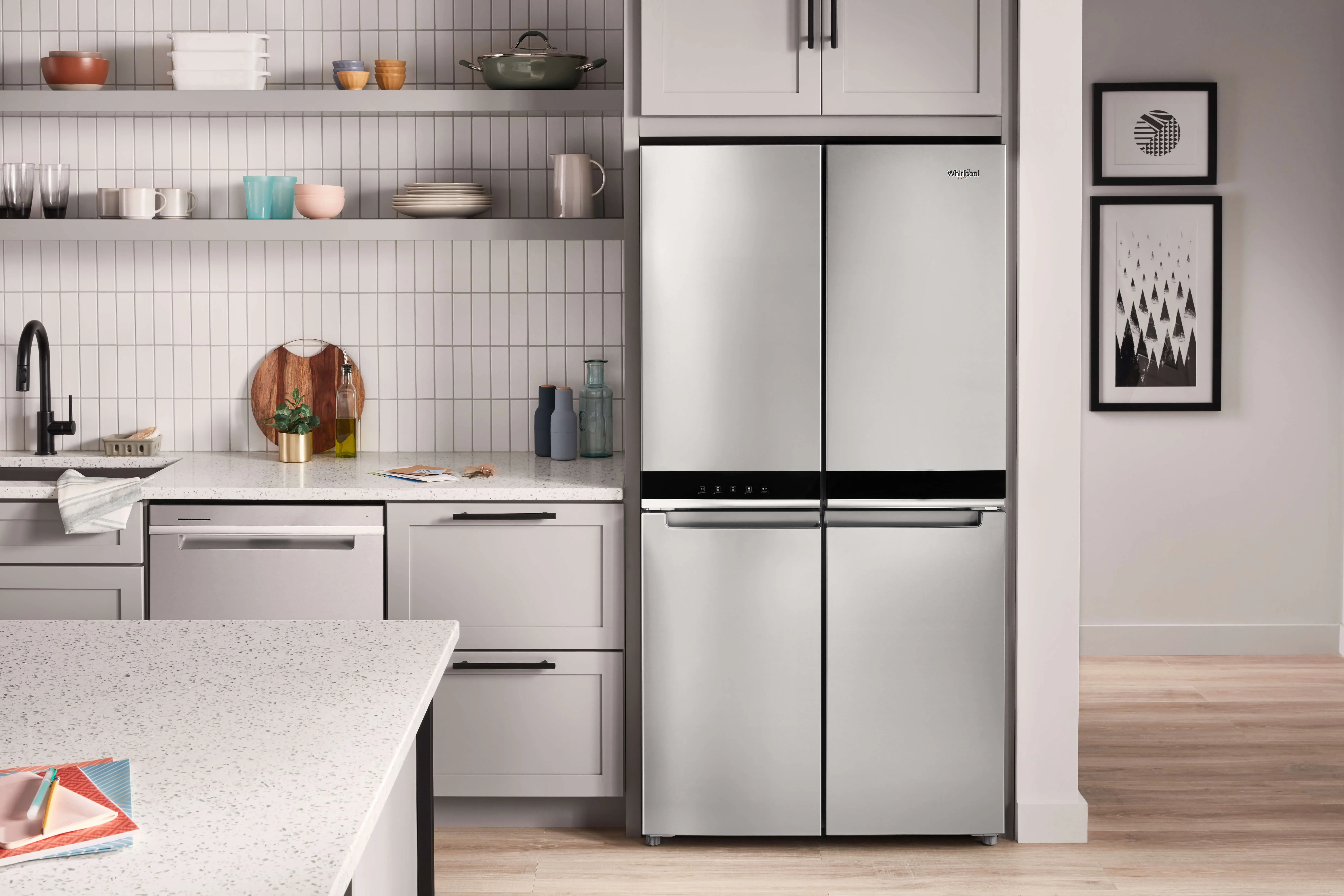 stainless steel whirlpool refrigerator in kitchen with white cabinets and island