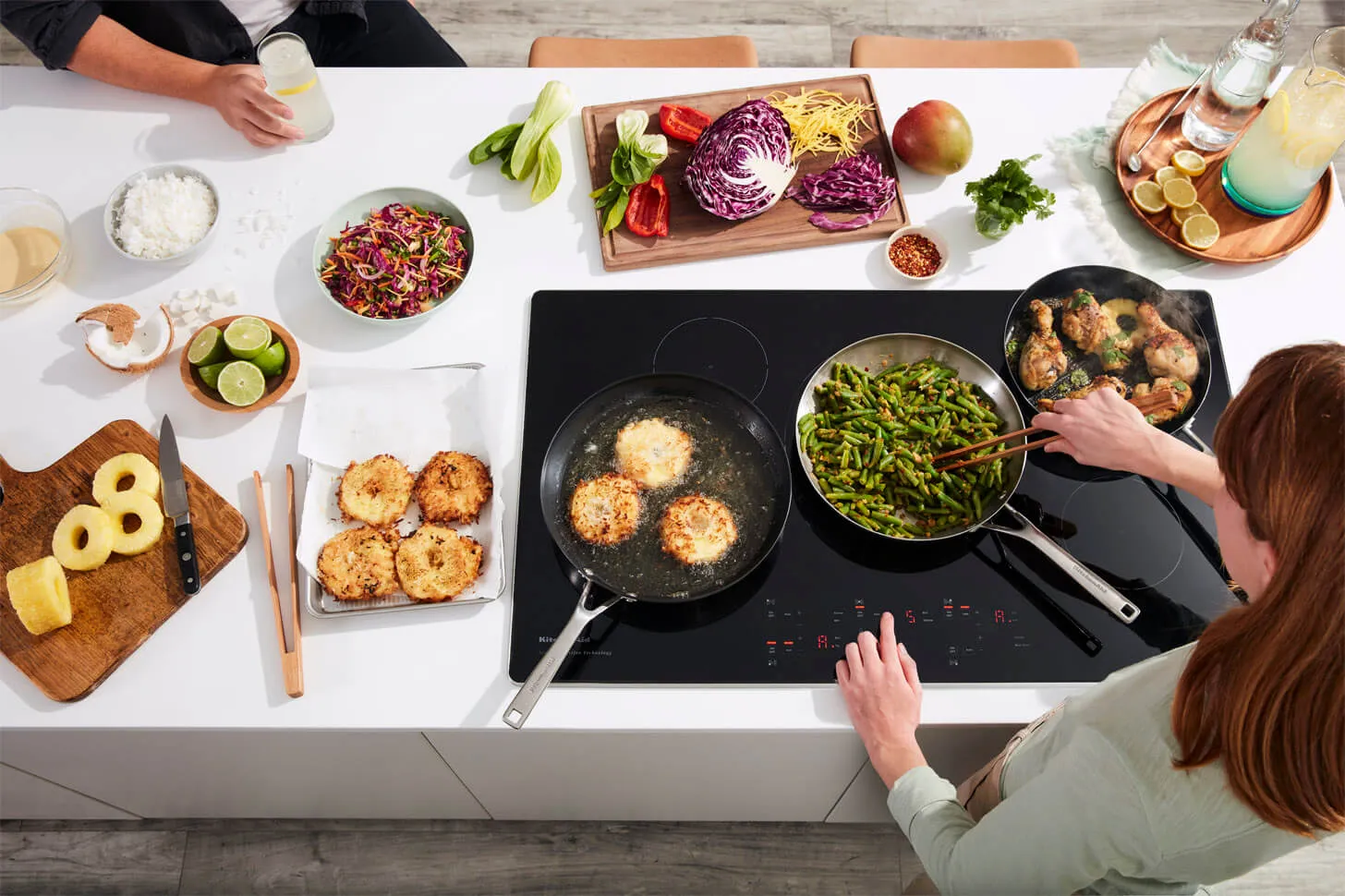 Person cooking in a kitchen with appliance rebate savings