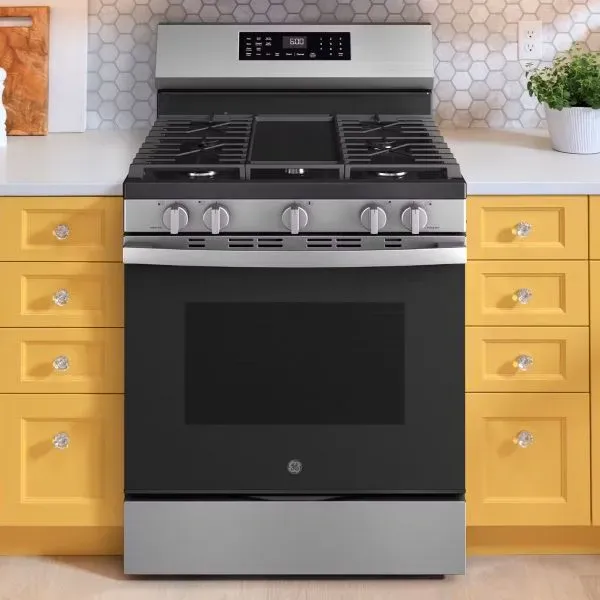 Woman using a modern double wall oven in a kitchen