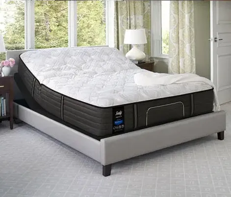 Sealy mattress on a platform bed near a window