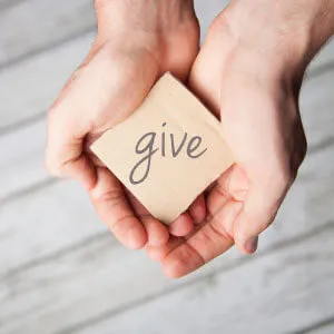 Hands holding the word give