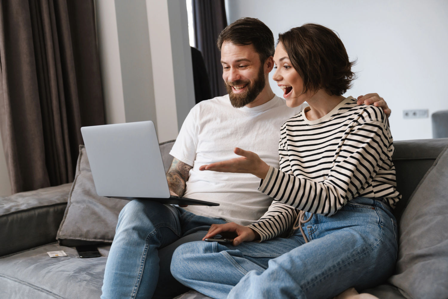 Couple reviewing a credit application together on a laptop at home