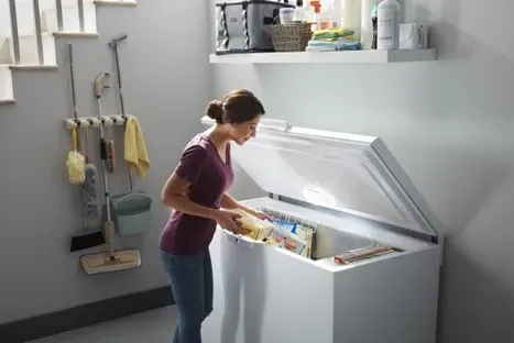 woman standing at open chest freezer