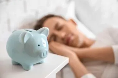 man sleeping next to blue piggy bank