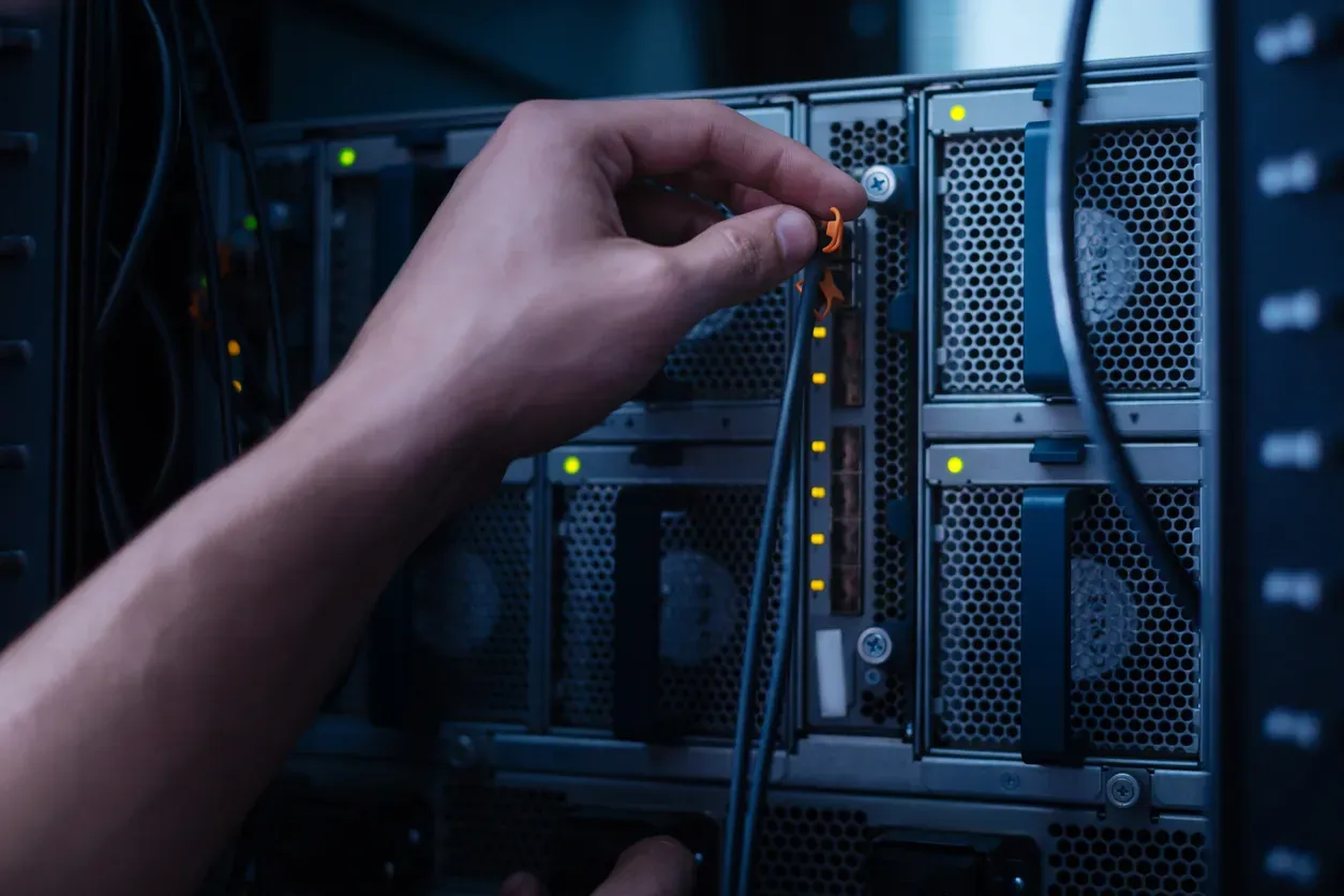 Modern living room with a large flat-screen TV mounted on a gray textured accent wall, wood paneling, a low dark coffee table with decor and green fruit, and a gray sectional sofa.