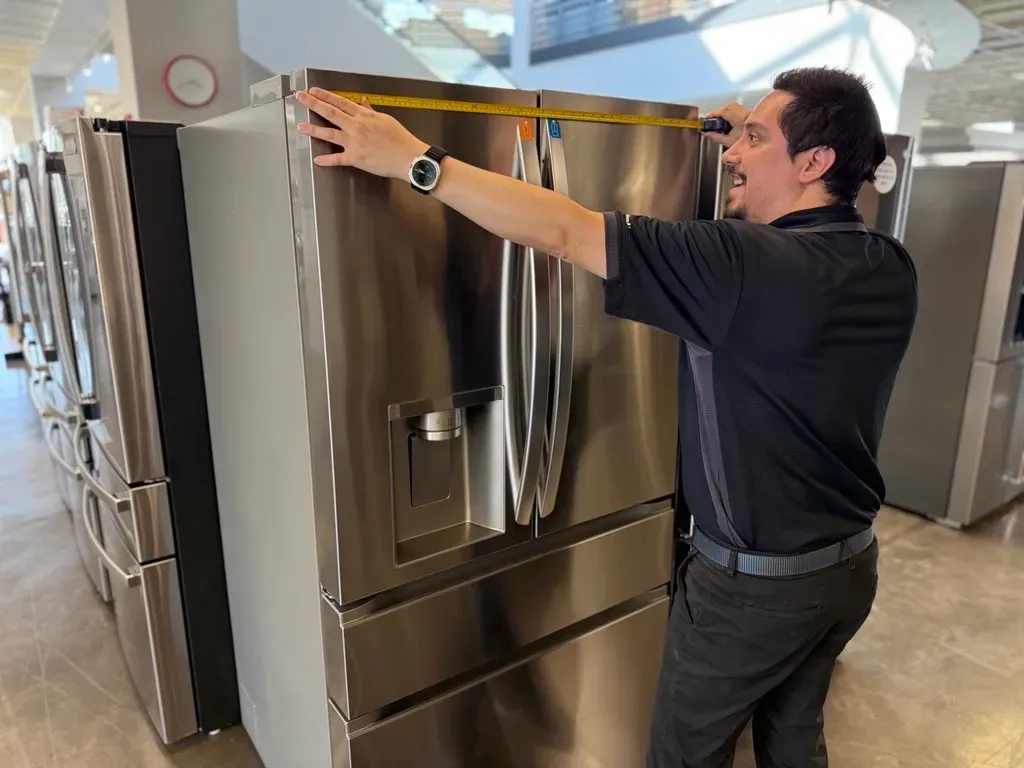 Image of the Queen City man measuring the fridge