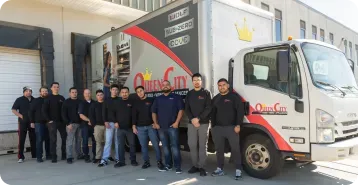 A team of Queen City delivery drivers standing in front of a Queen City delivery truck