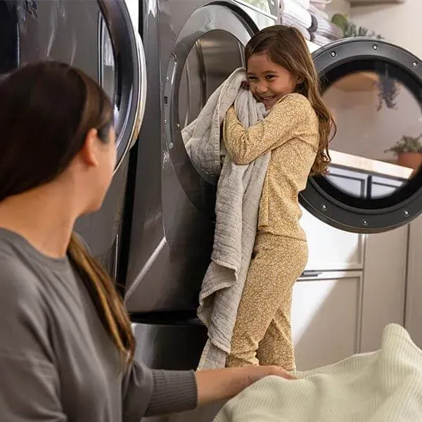 Woman and child by a front-load washer and dryer