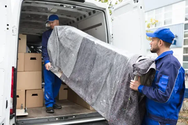 Professional delivery team unloading furniture from a moving truck