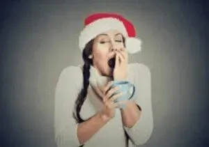 woman in santa hat yawning