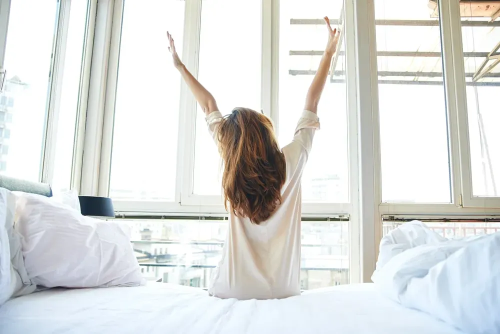 Woman-stretching-in-bed-in-the-morning-sitting