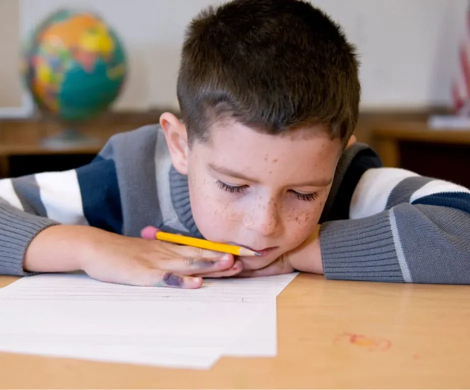 a sleepy young student with head down on his desk