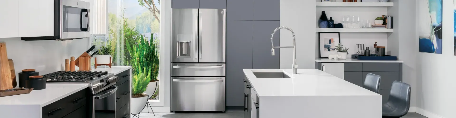 kitchen with white countertops and gray cabinets featuring a large, shiny, stainless steel refrigerator