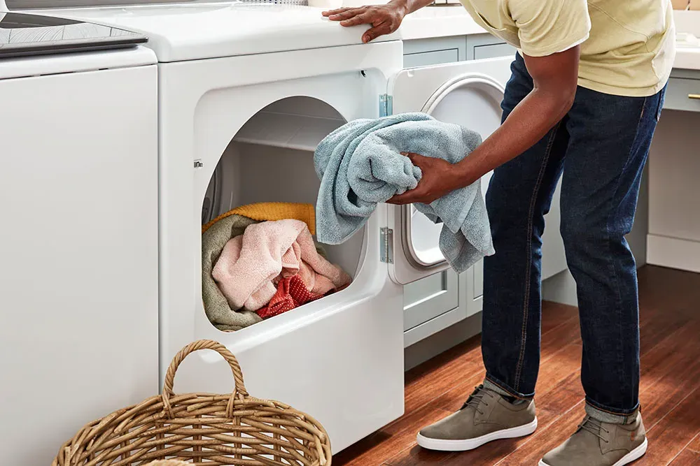 Image of a person taking laundry out of a dryer